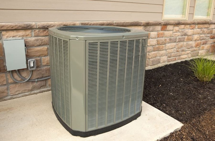 Outdoor air conditioning system on concrete slab on the side of a house